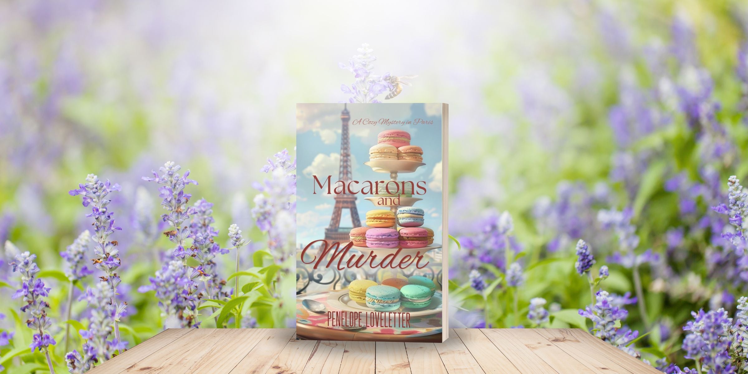 paperback book, Macarons and Murder, on a table with purple flowers in background